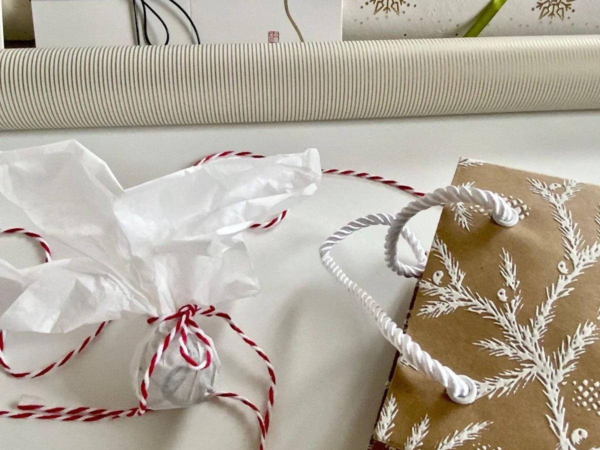 Several small wrapped gifts with reusable ribbons and bags.